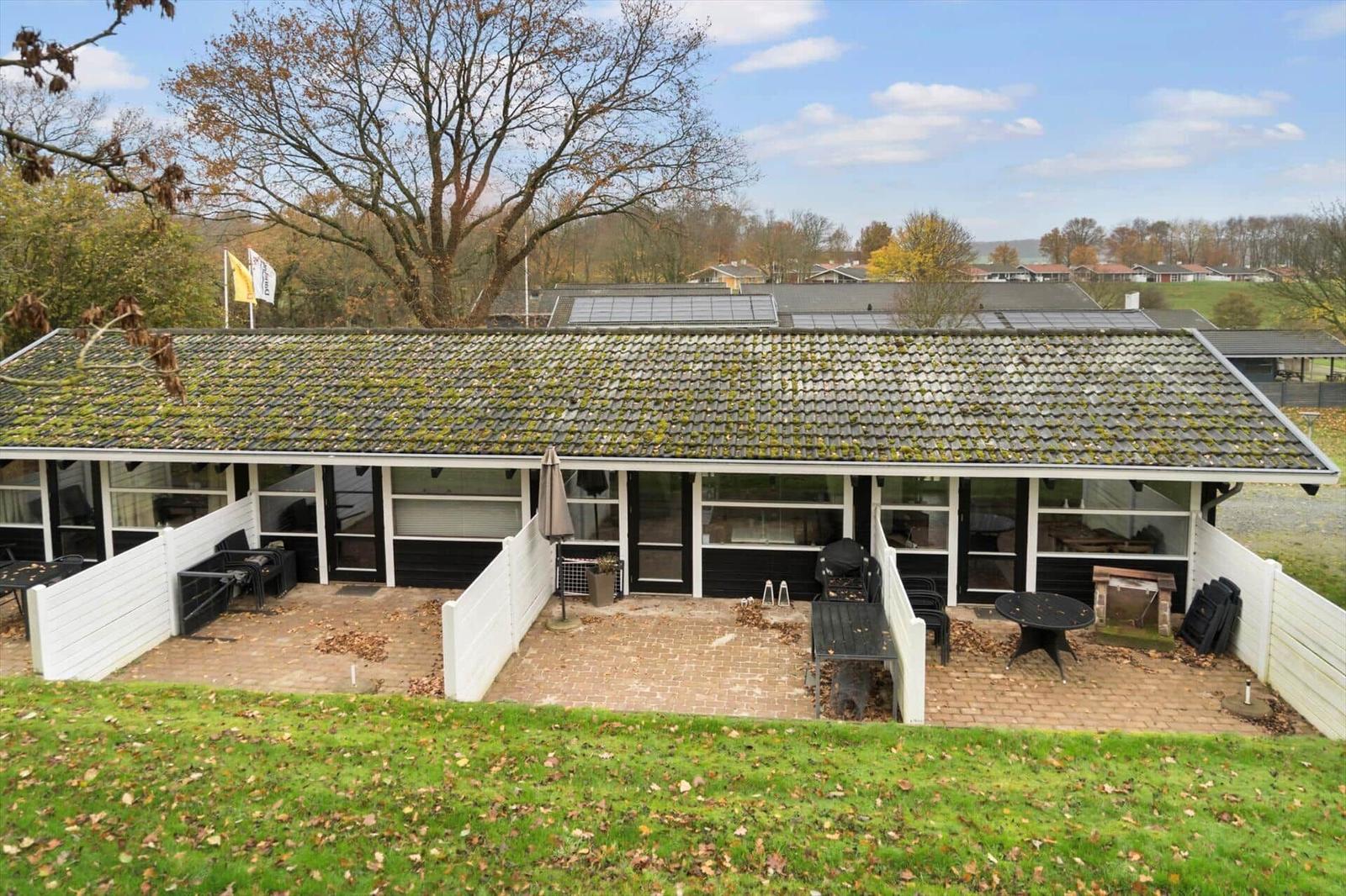 House with terrace, garden, and view of woods and hills.