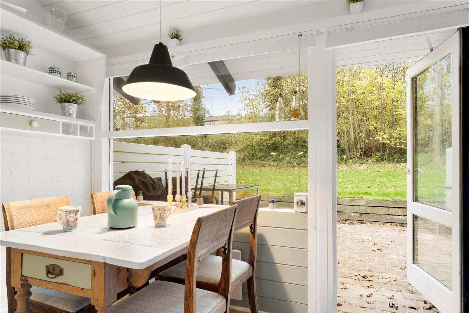 Dining area with table, chairs, and garden view through window
