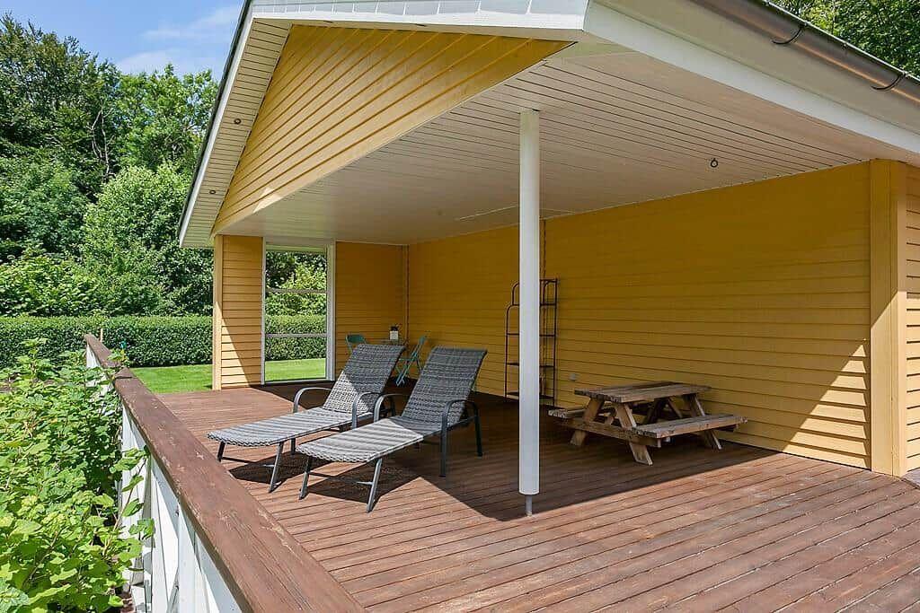 Deck with loungers, picnic table, and wooden floor under roof