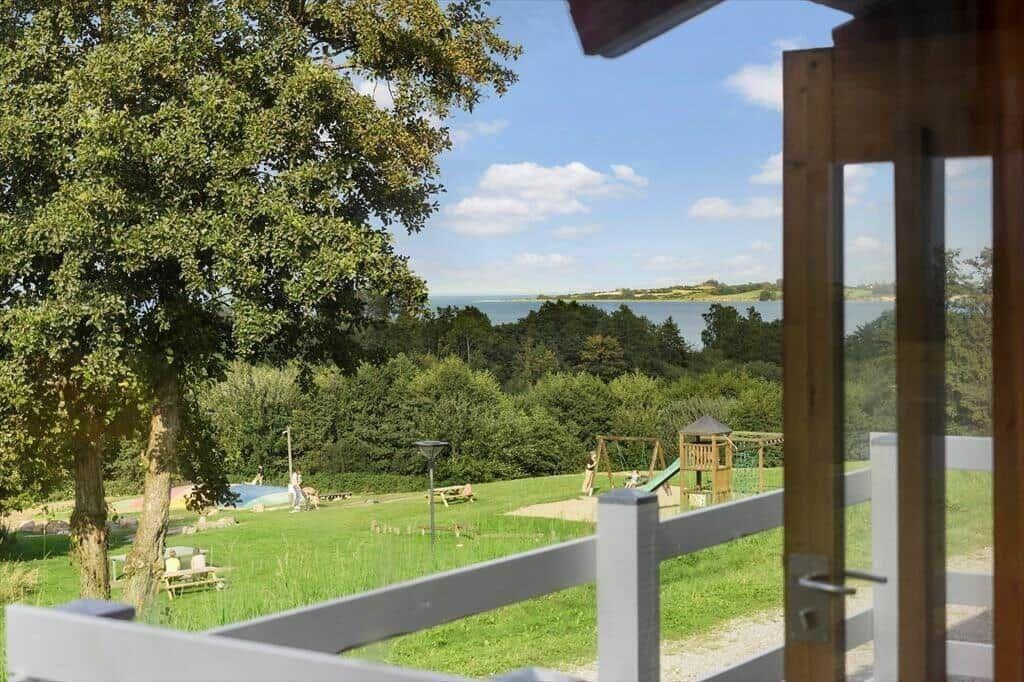 From the terrace, you can see a green garden with a playground and a lake.