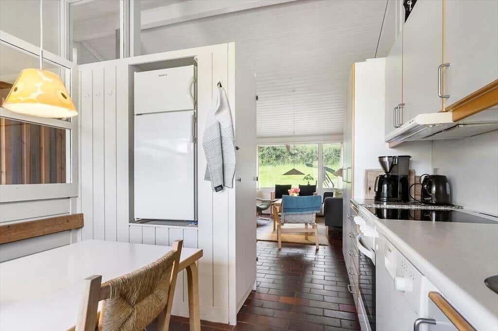 Kitchen with countertop, refrigerator, and view into living room.