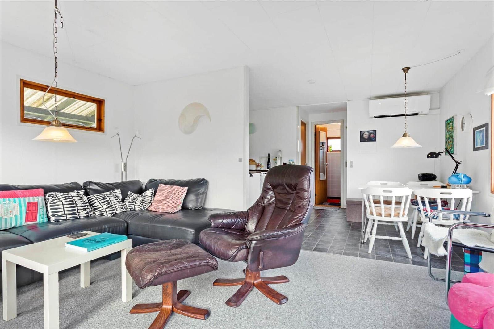 Living and dining area with sofa, leather chair, and table