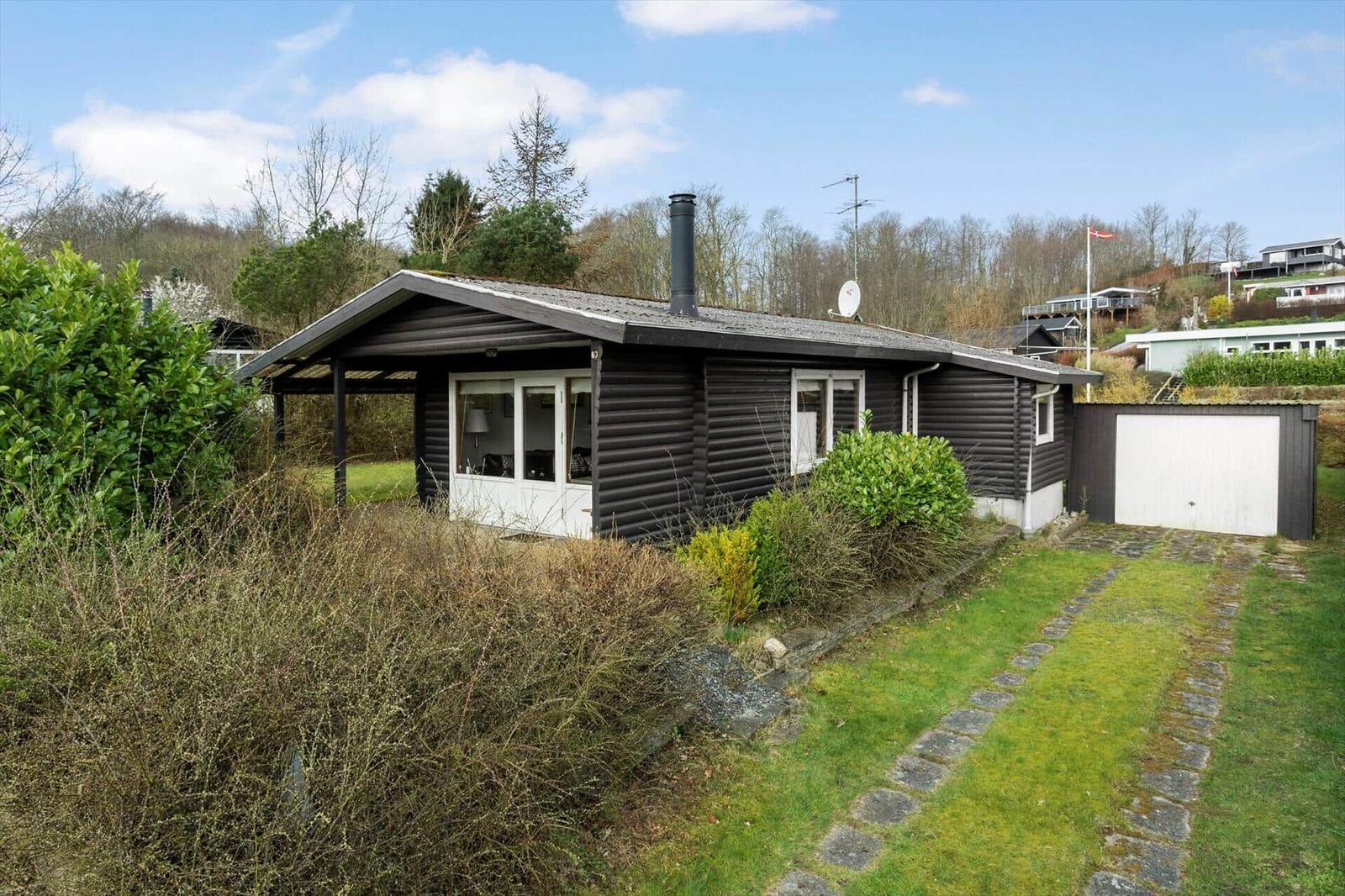 A black-clad house with white windows and a garage.