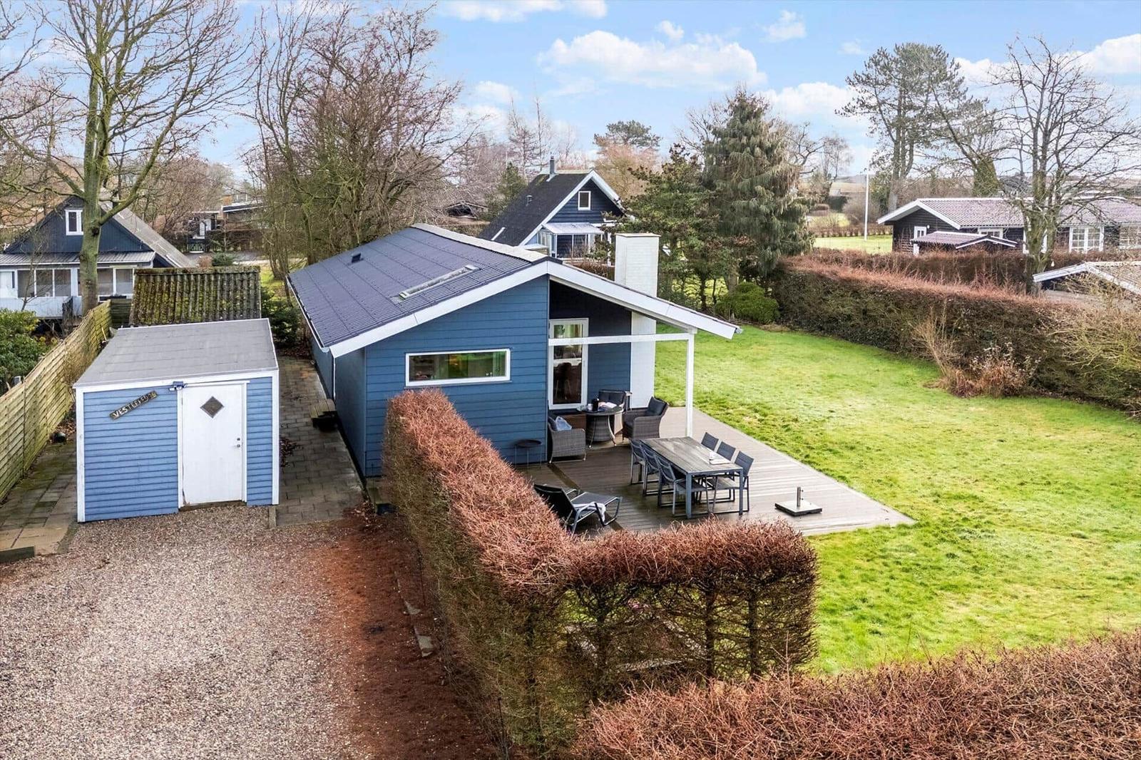 Blue vacation home with terrace and garden. Attached shed.
