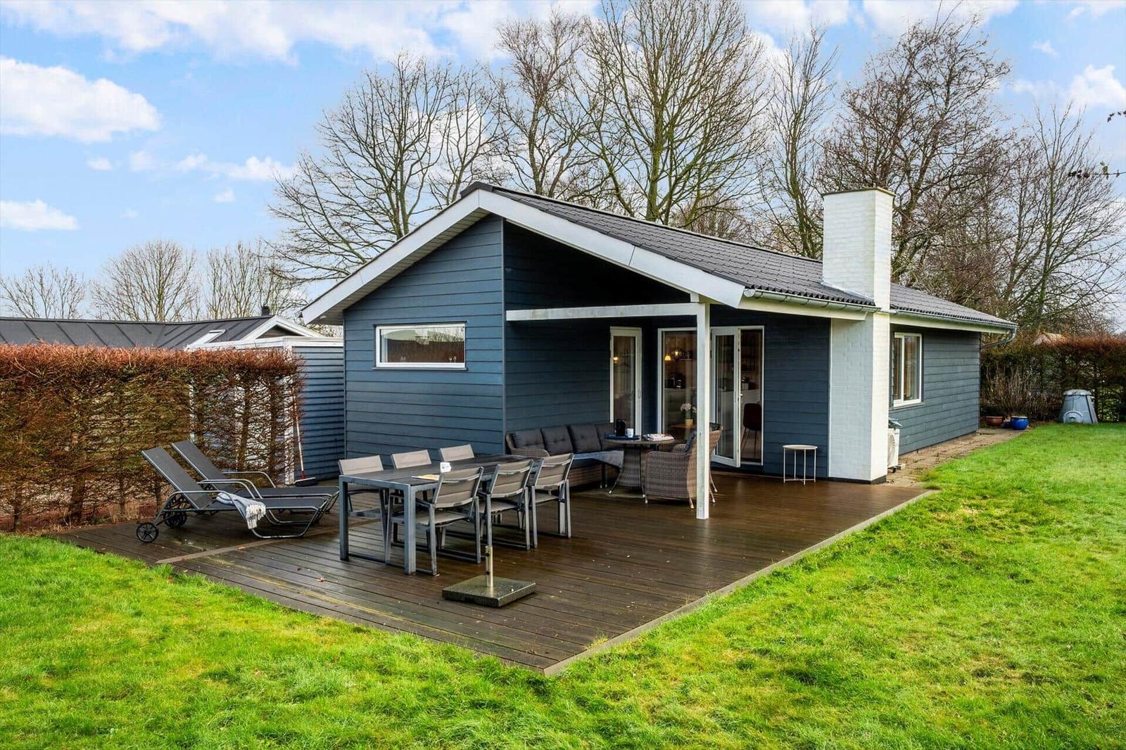 A house with a terrace, garden, and outdoor seating.