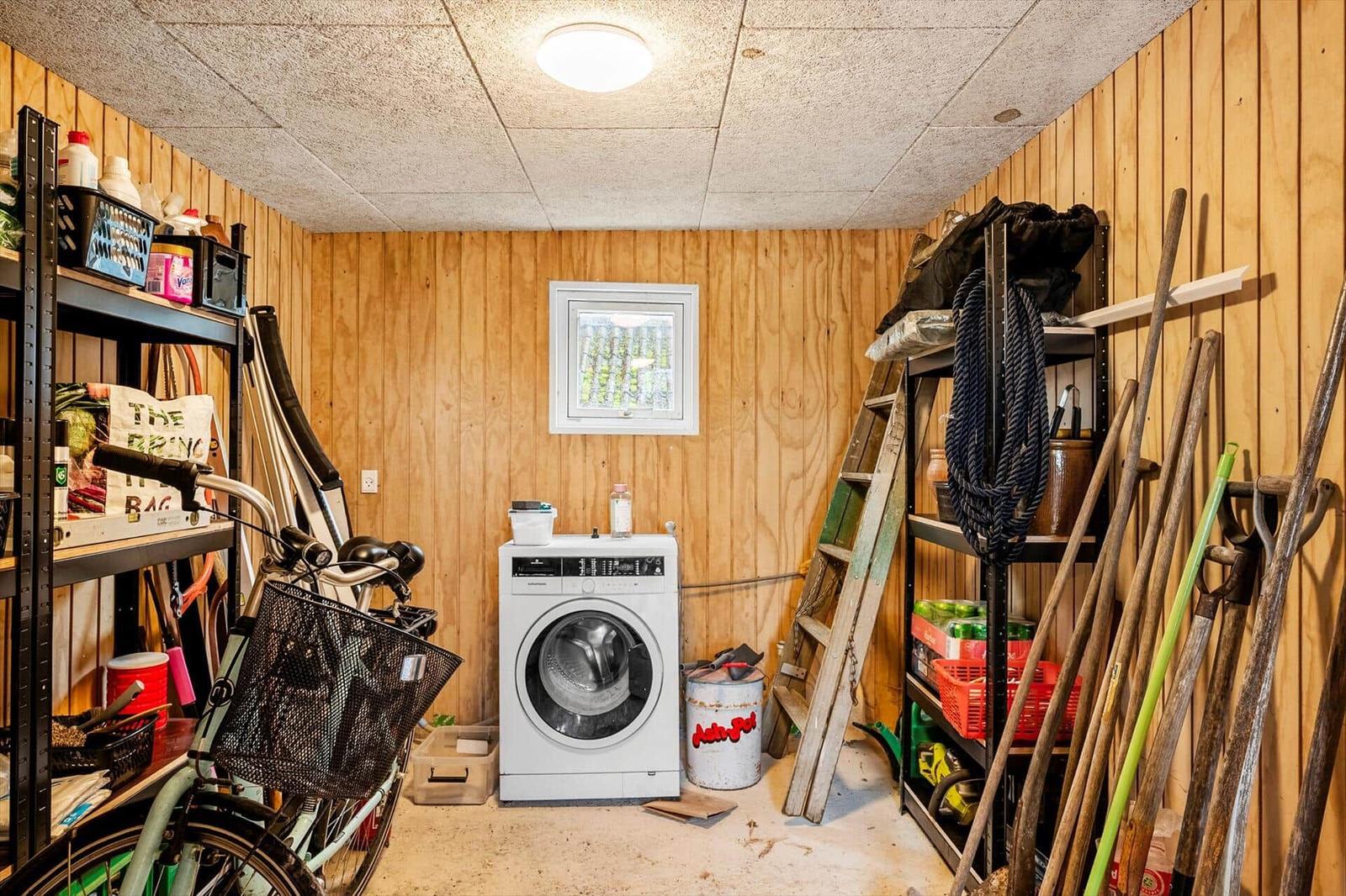 Room with washing machine, tools, and bicycle