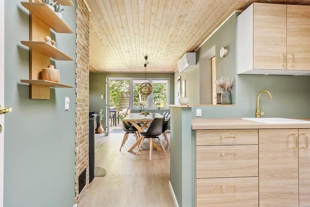 Kitchen with wooden surfaces and dining area with table and chairs.