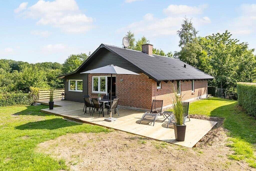 House with terrace, seating, and garden.
