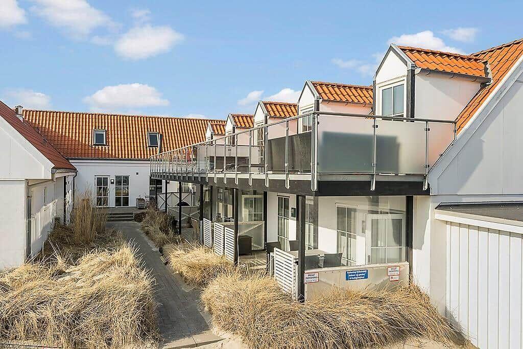 Modern holiday homes with balconies and red tiled roofs in a well-maintained setting.