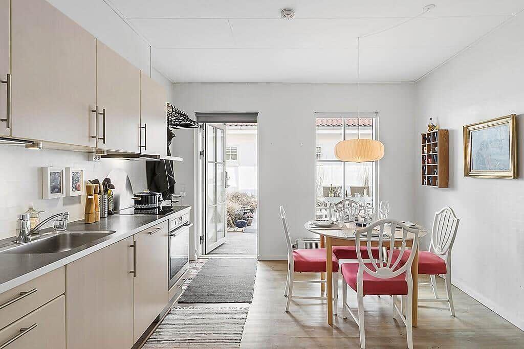 Kitchen and dining area with table, chairs, and window.