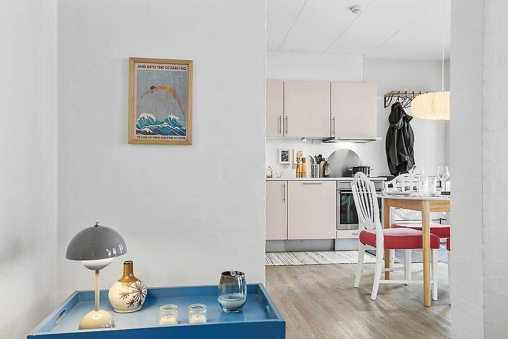 Kitchen and dining area with table, chairs, and cabinets. Glasses are on the table.