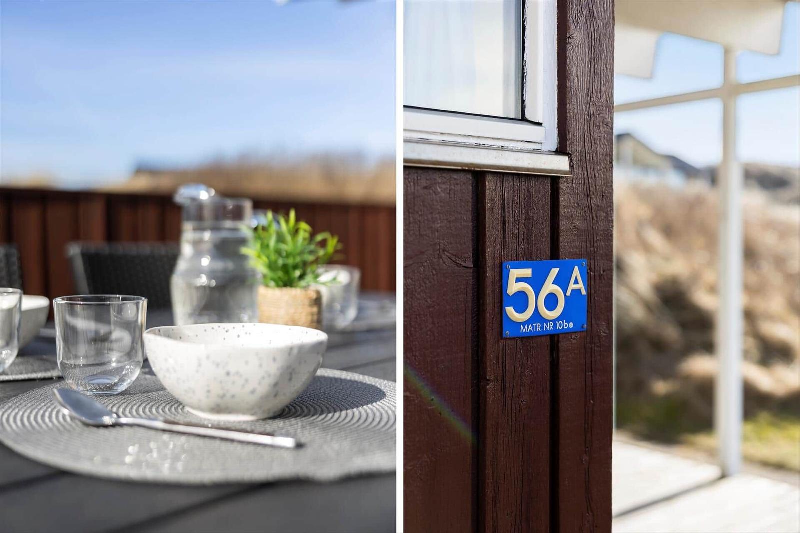 Outdoor area with table and chairs. House number 56A on the facade.