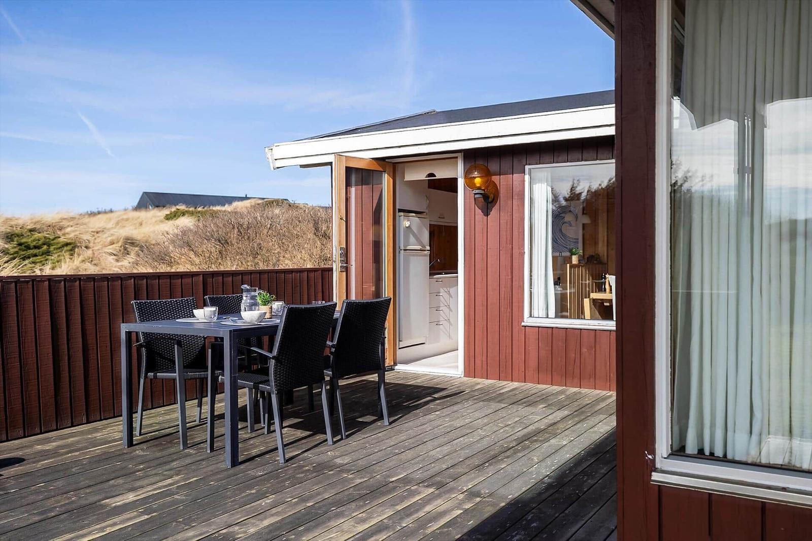 Deck with table and chairs, view of the coastal landscape.