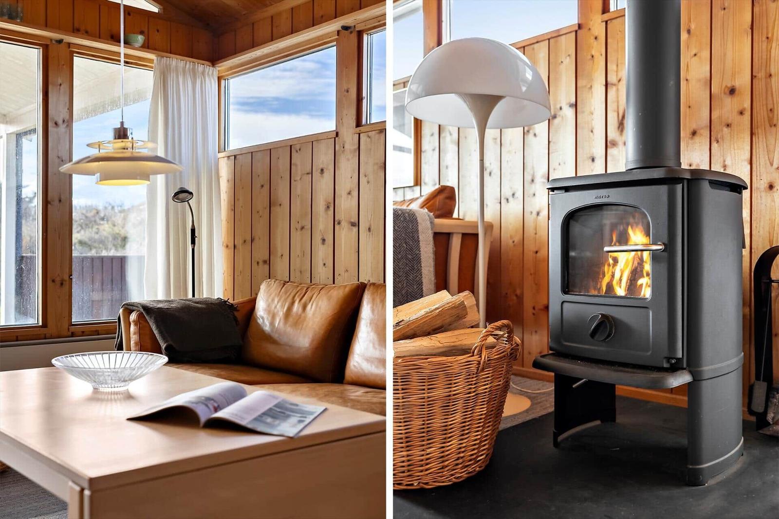 Living room with wooden walls and sofa. Wood-burning stove with fire.