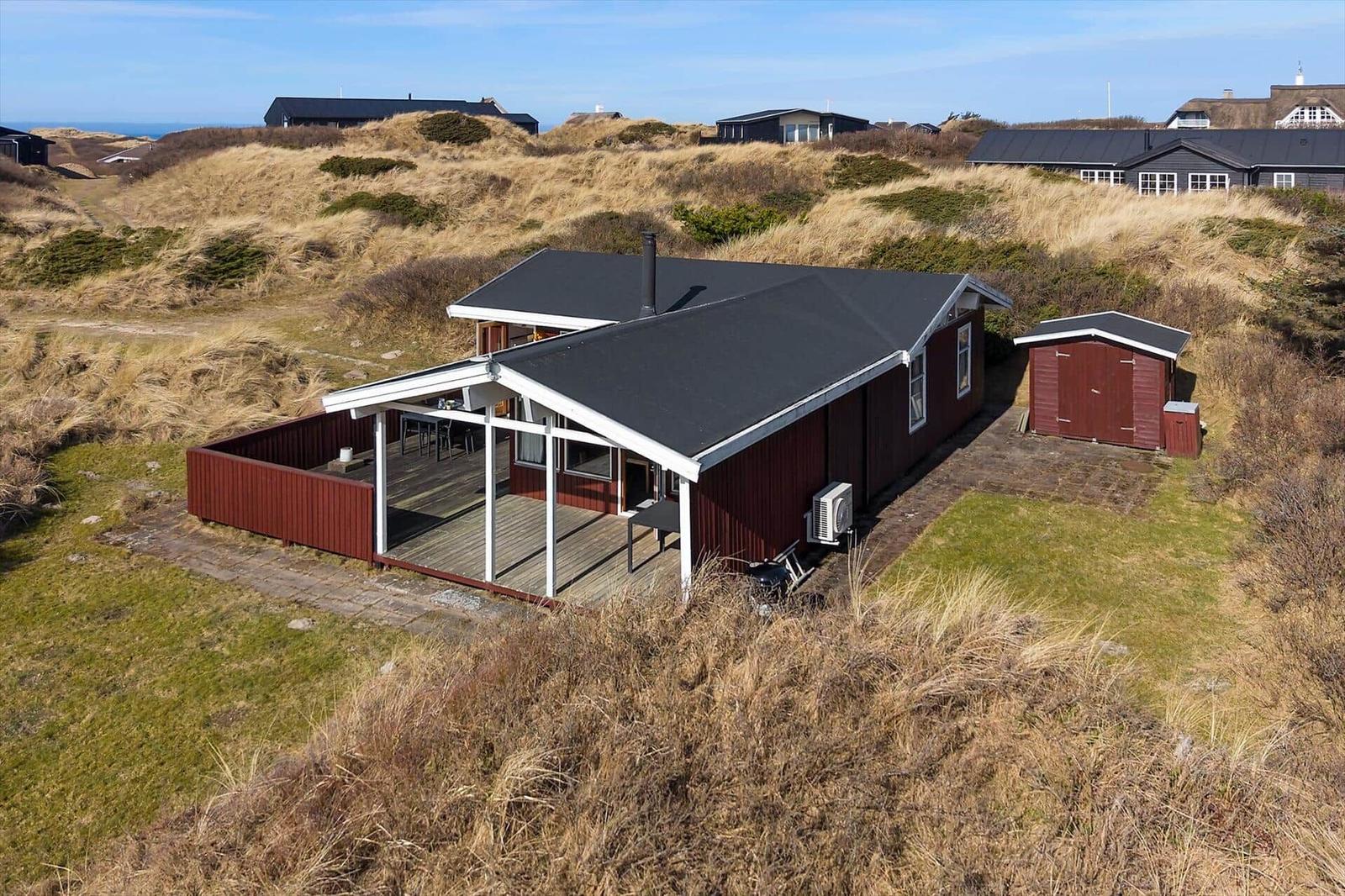 Red house with terrace and shed on dune landscape