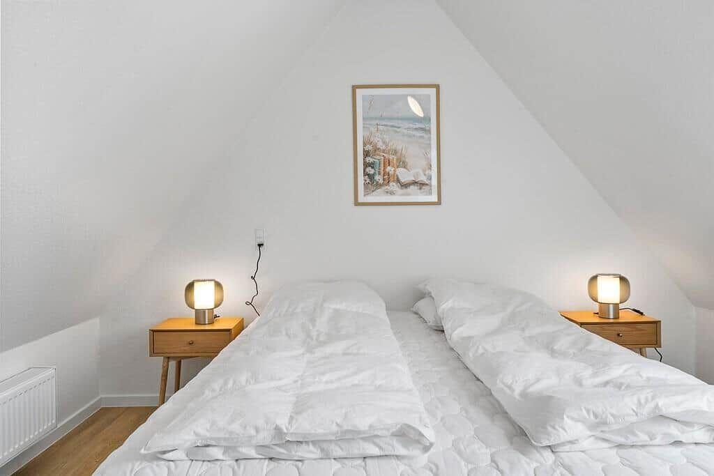 Bedroom with double bed, two nightstands, and wall decoration.