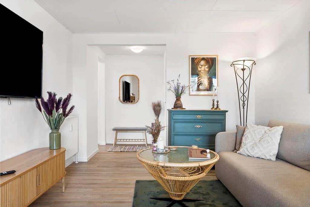 Living room with sofa, coffee table, and TV mounted on the wall.