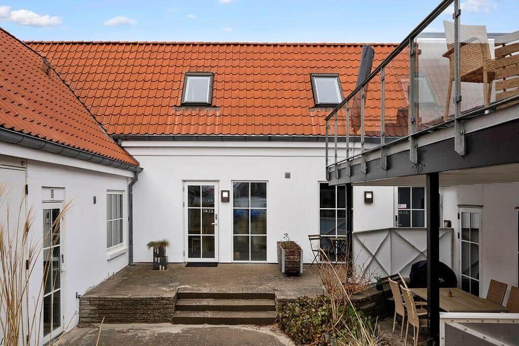House with red roof, terrace, and glass railing