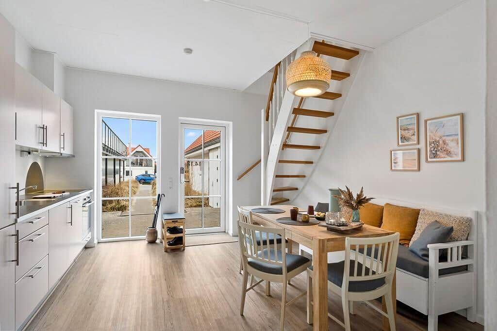 Kitchen, dining area, and staircase to bedroom with window to street.
