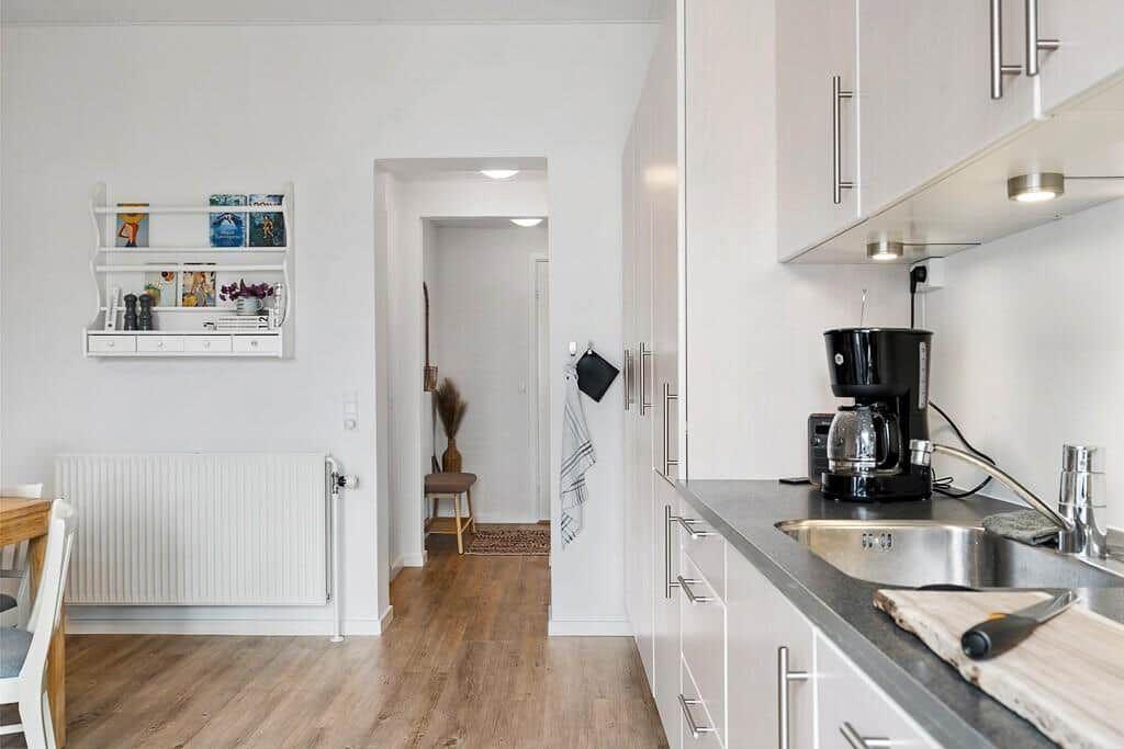 Kitchen with countertop, coffee maker, and passageway to living area.