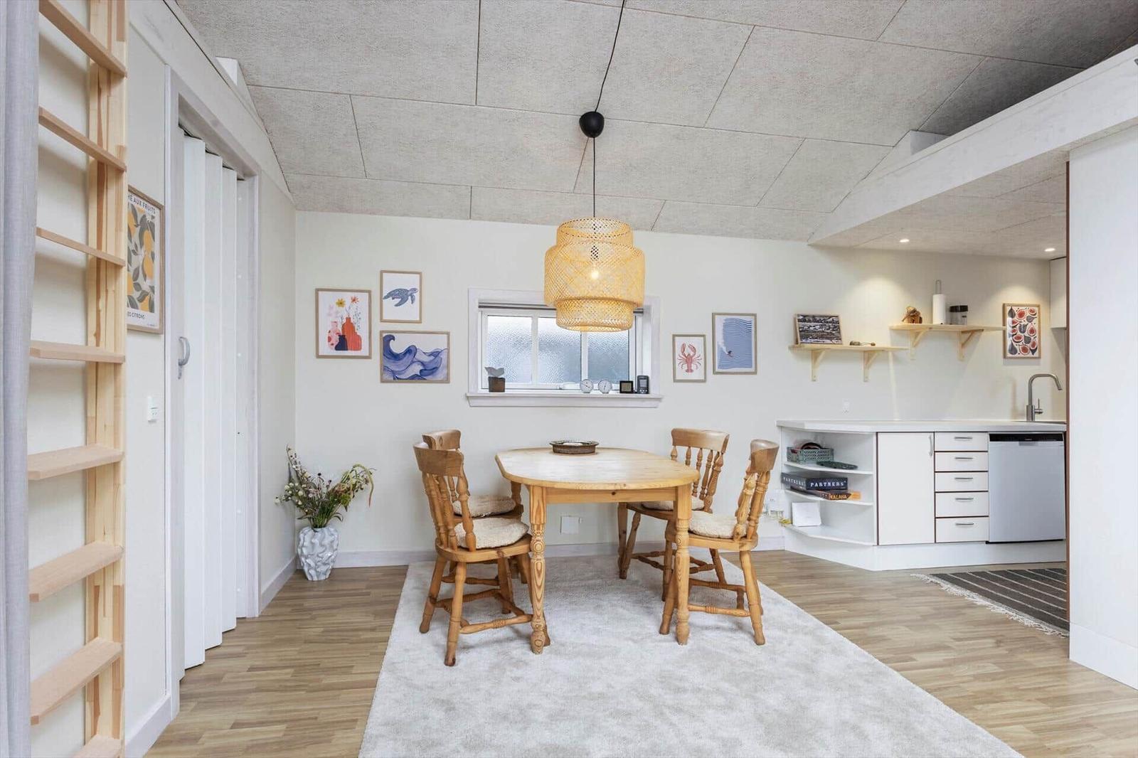Esszimmer mit Holztisch, vier Stühlen und Küchenbereich im Hintergrund.