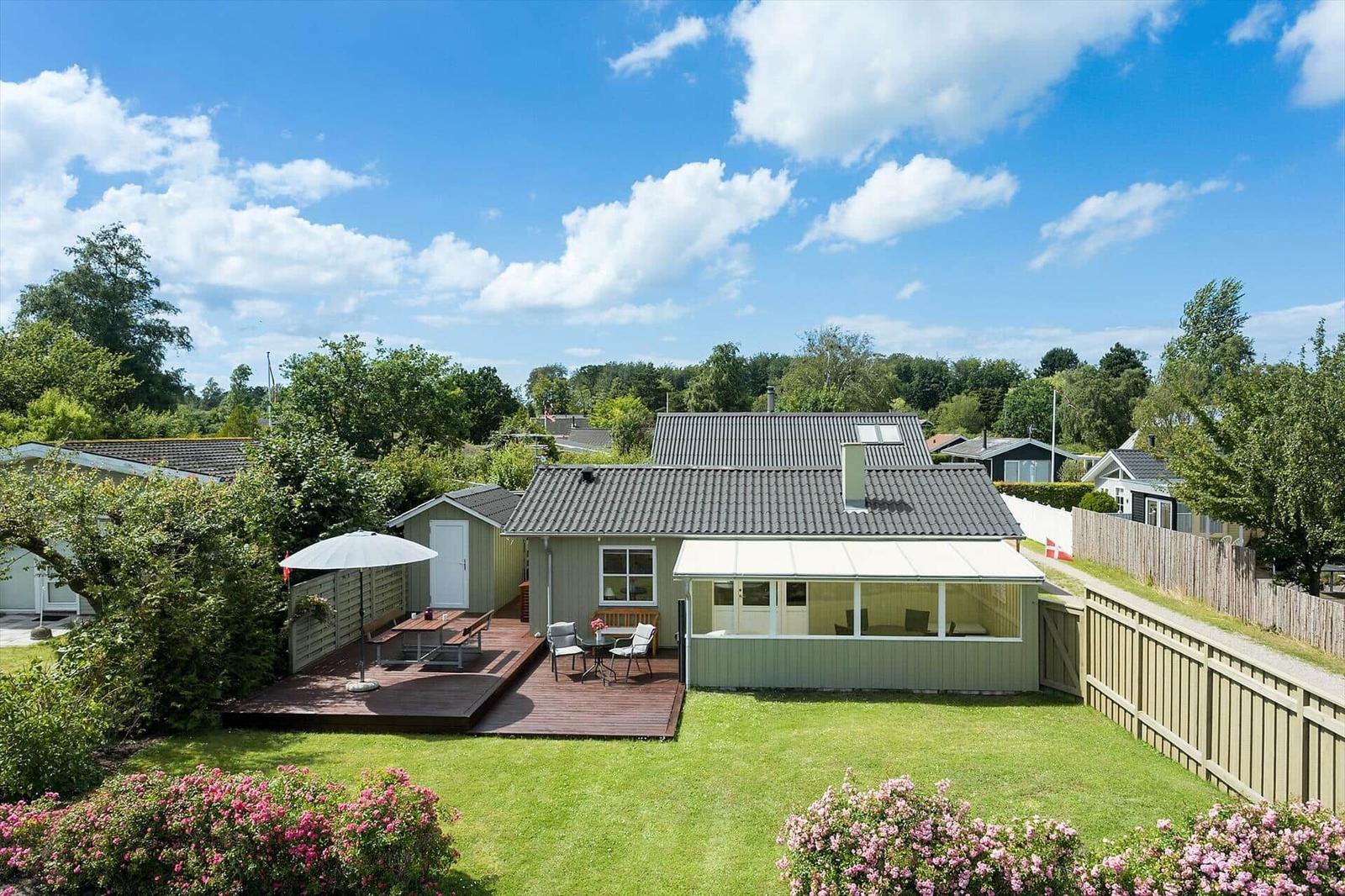 Haus mit Terrasse, Garten und Sitzgelegenheiten unter freiem Himmel.