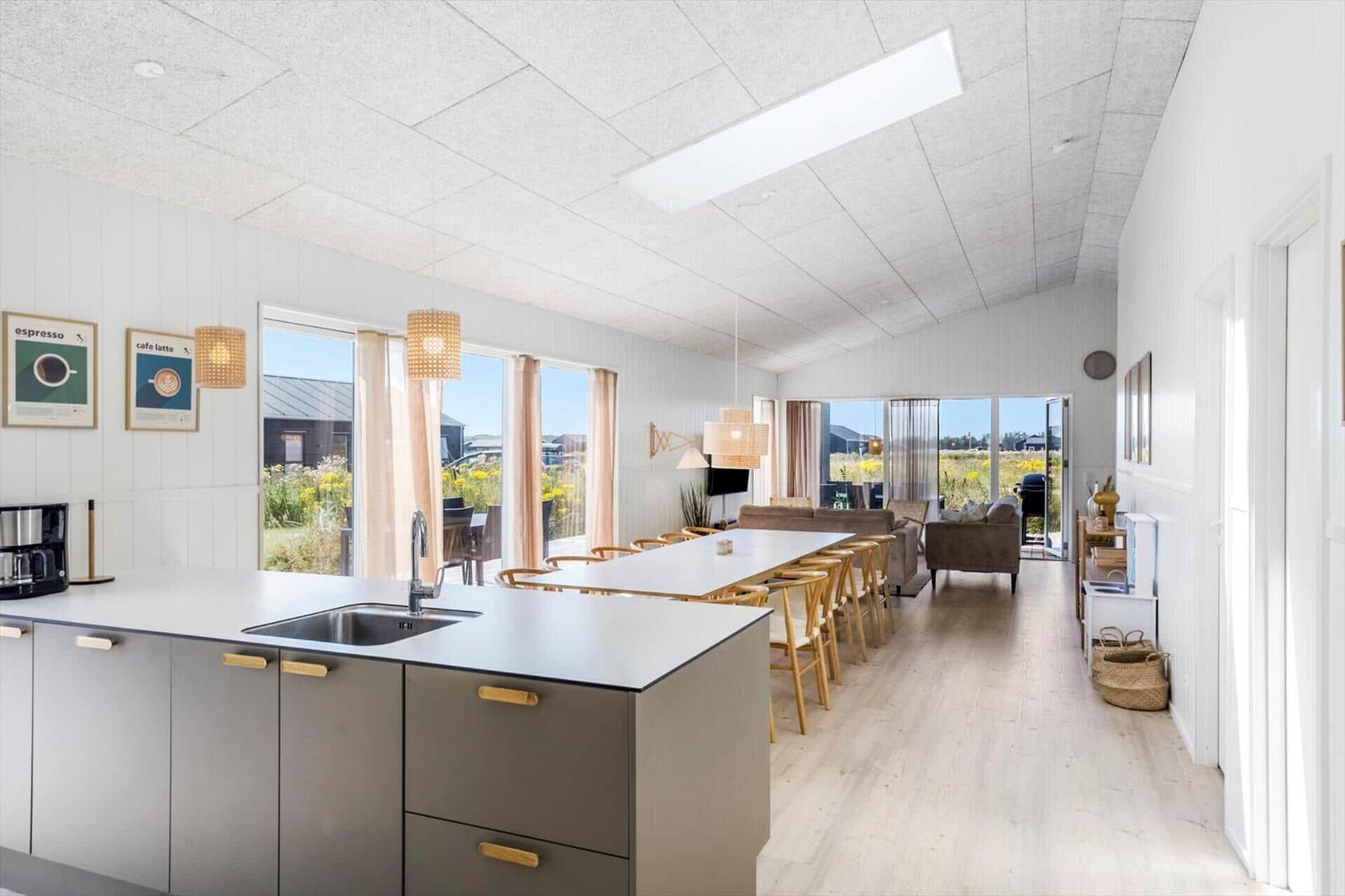 Küche mit Essbereich und Wohnzimmer mit Blick auf Grünflächen.