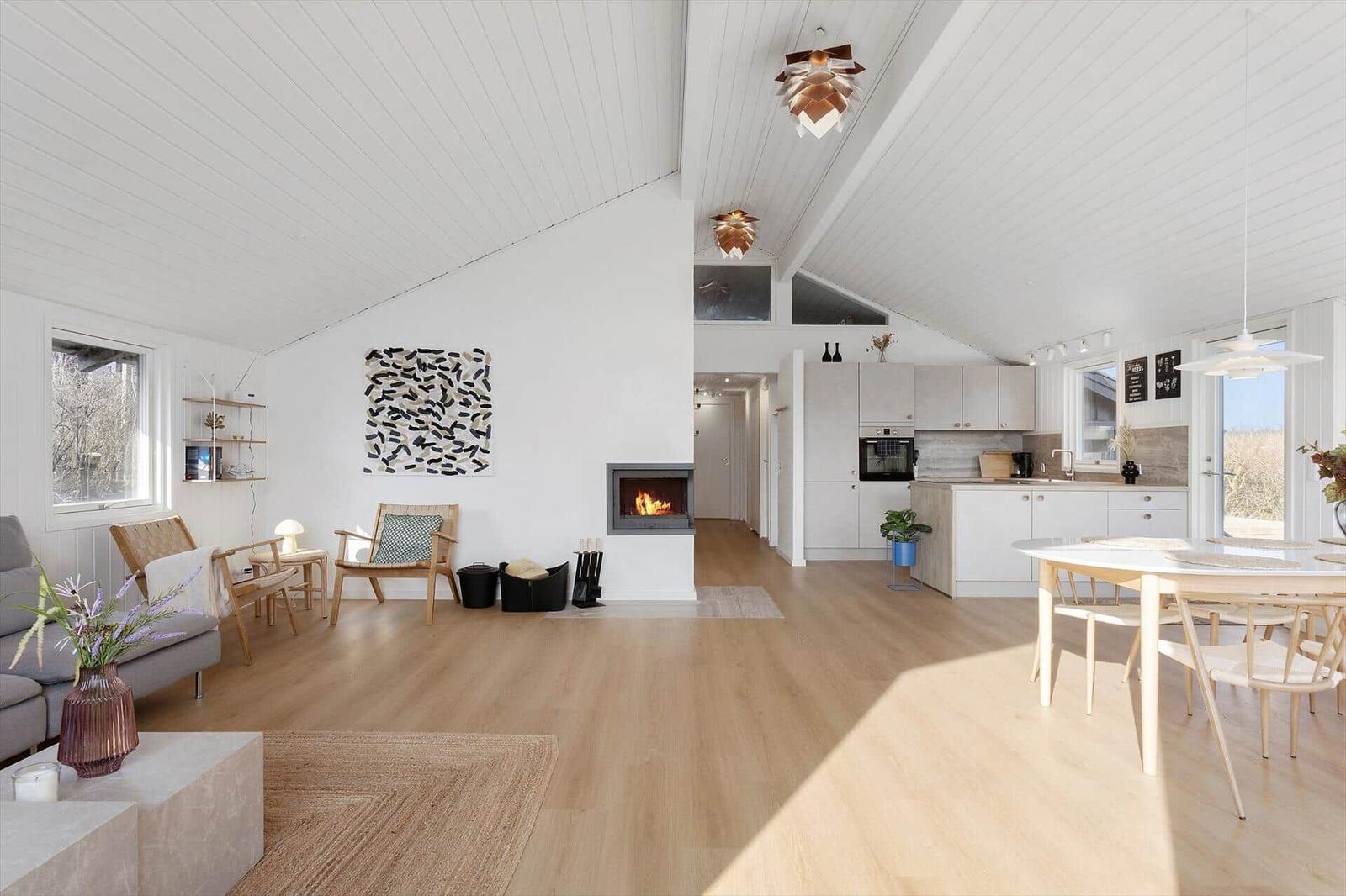 Open space with kitchen, dining area, and living area under high ceiling
