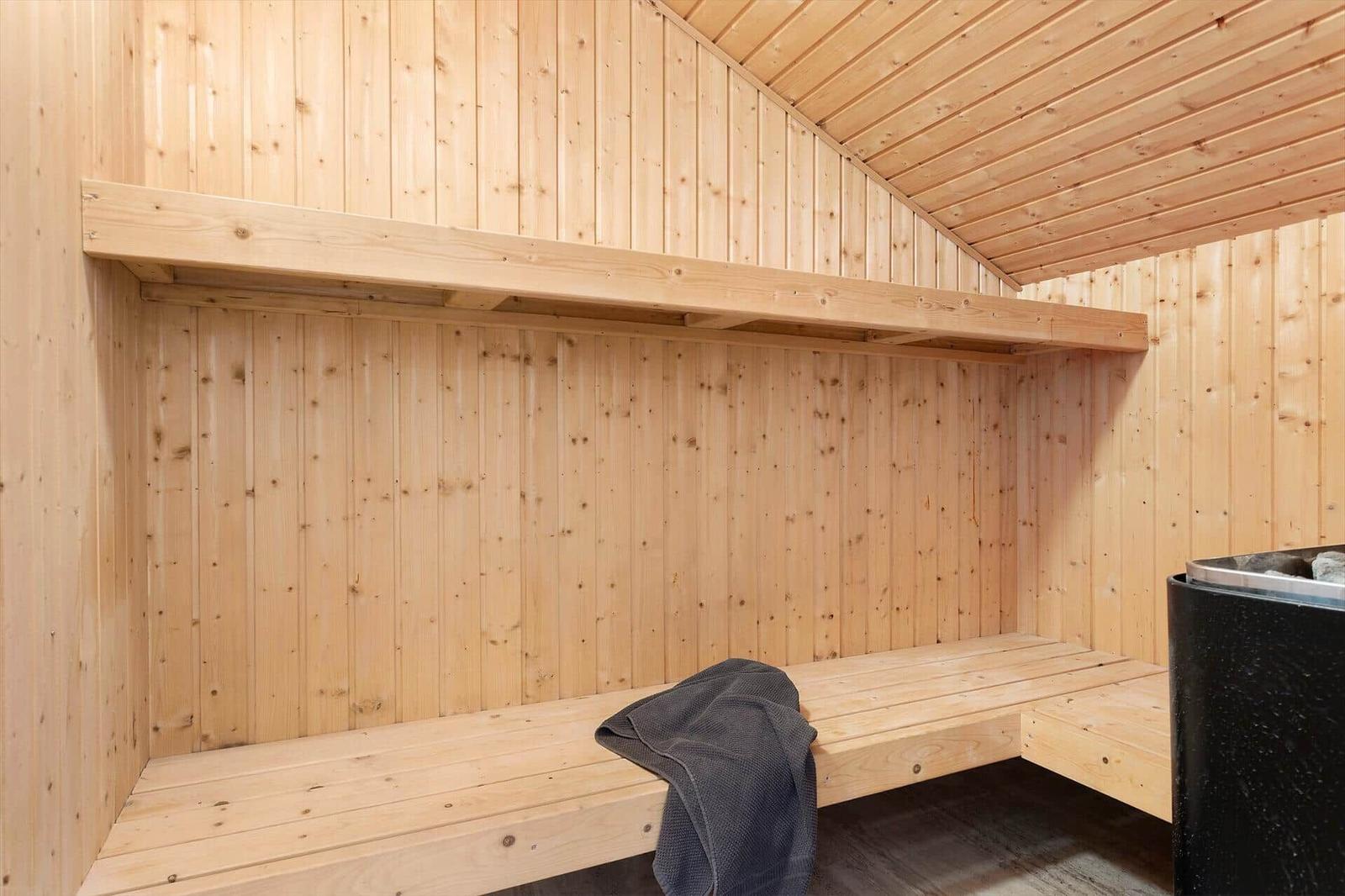 Wooden sauna with bench and heater