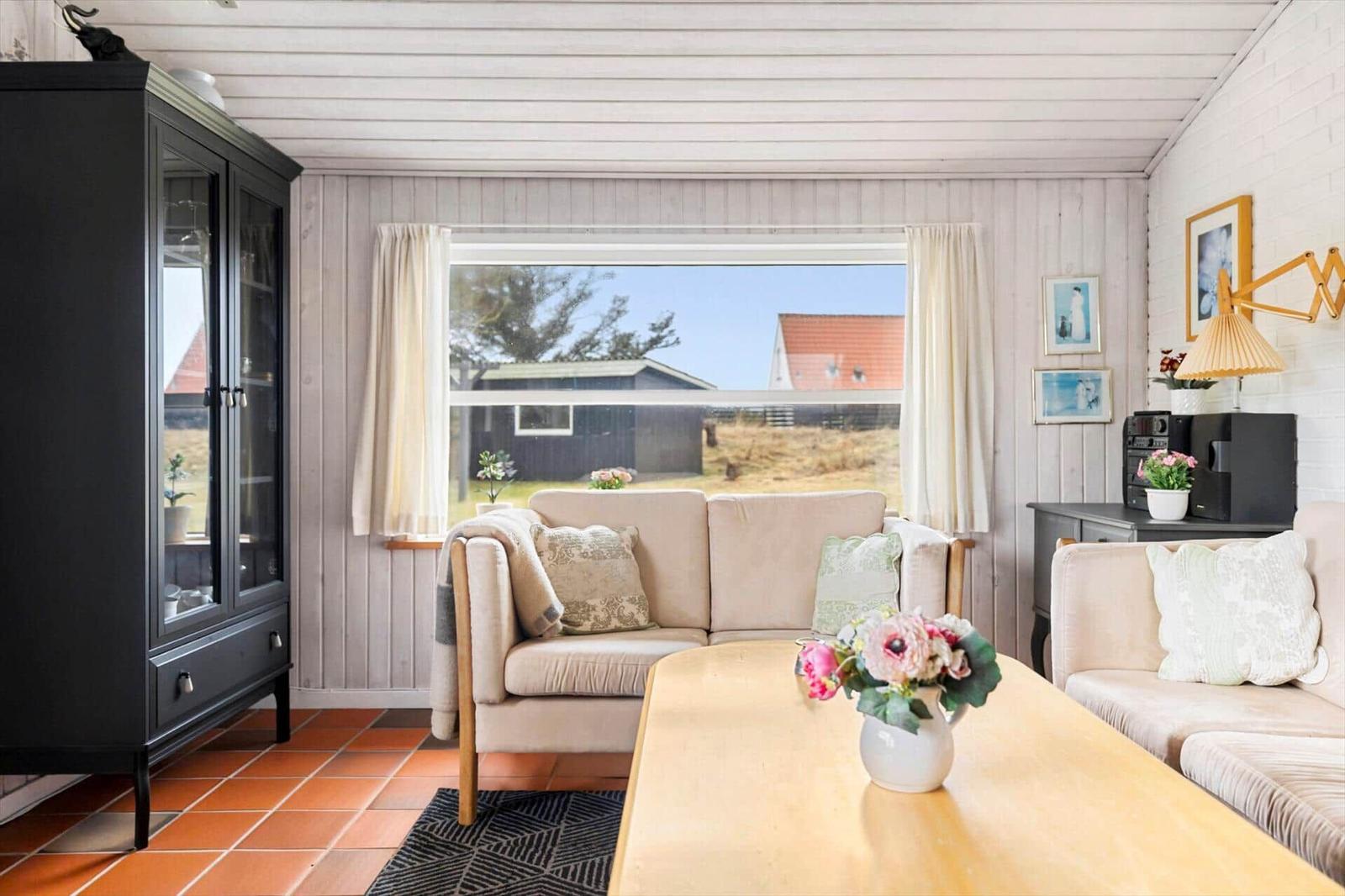 Living room with sofa, table, and view of the outdoor area.