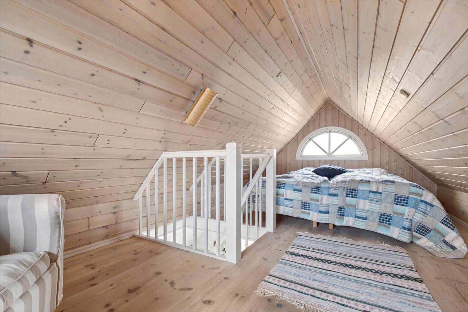 Bedroom with wooden walls, bed, seating, and window