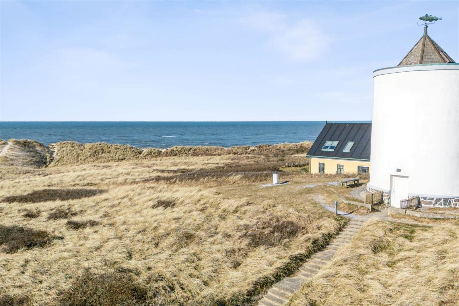 House next to windmill with view of the sea