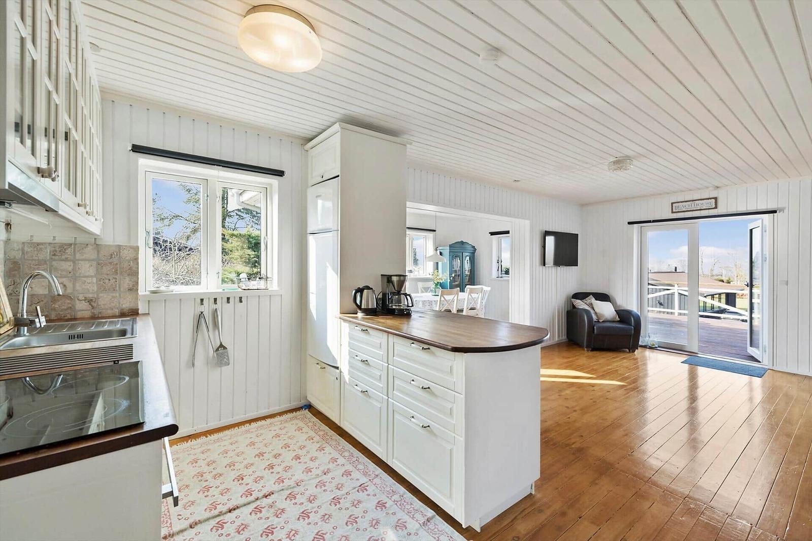 Kitchen with island, dining area, and bedroom in the background.