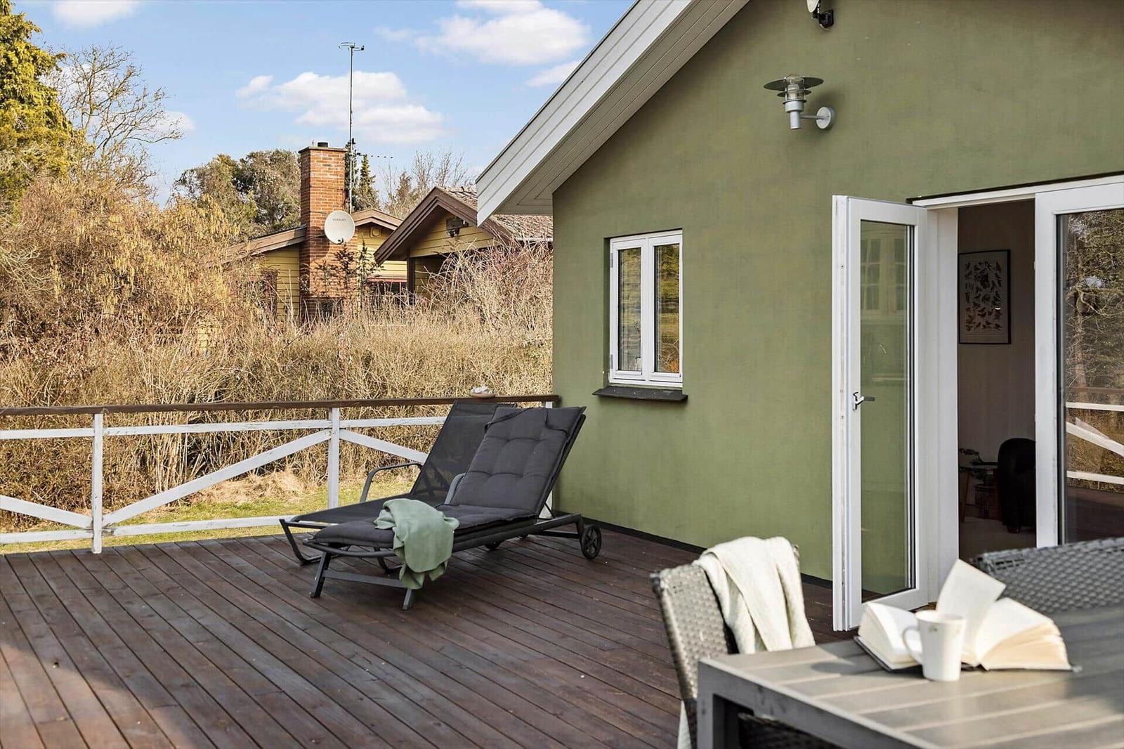 Deck with lounge chair and table. Sliding door leads to the apartment.