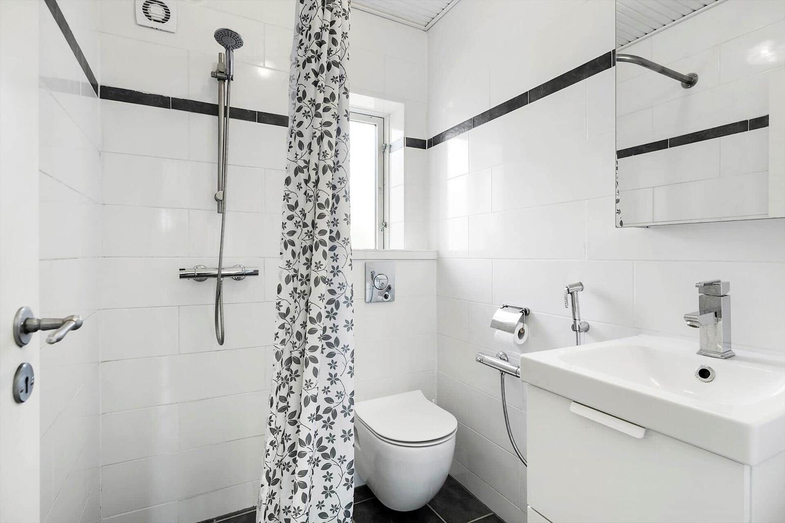 Bathroom with shower, toilet, and sink.