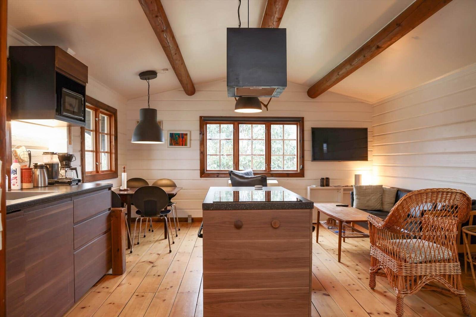 Küche mit Essbereich und Wohnzimmer mit Holzdielen und Balken.
