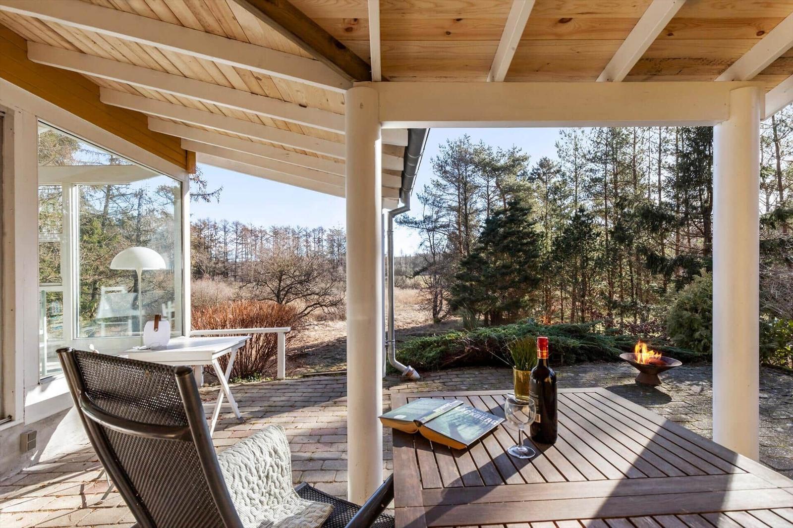 Terrasse mit Tisch, Stuhl und Feuerkorb im Wald