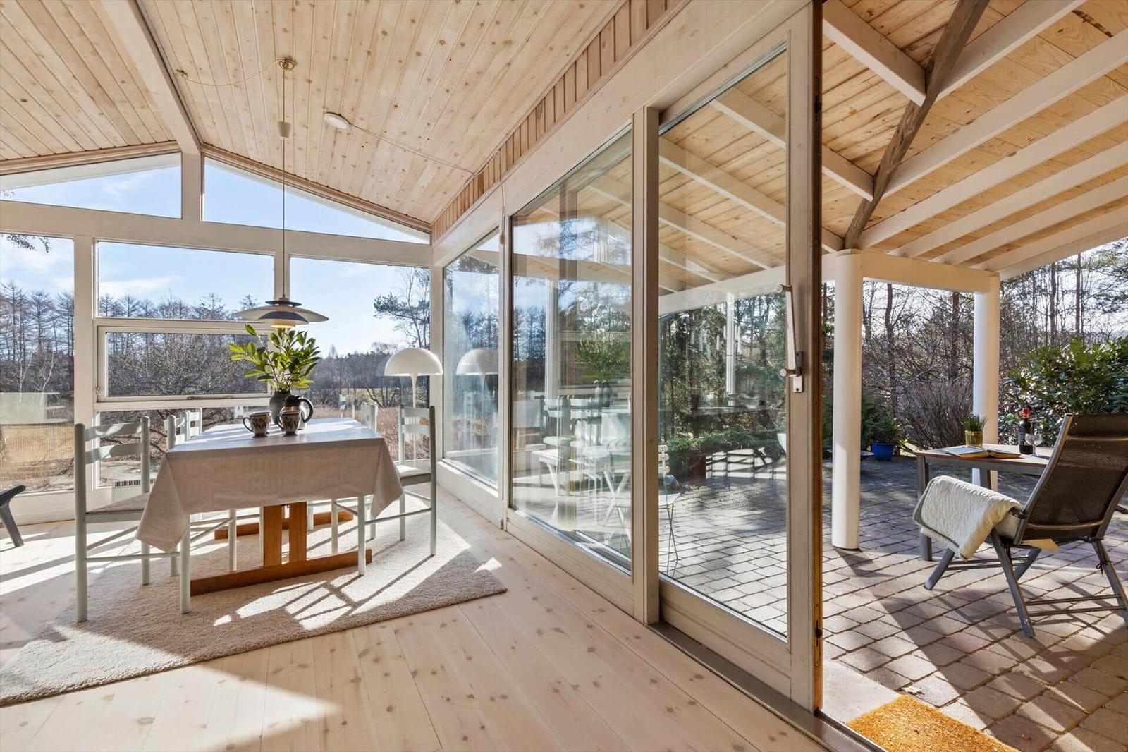 Essbereich mit Tisch und Stühlen, große Glasfront zum Garten