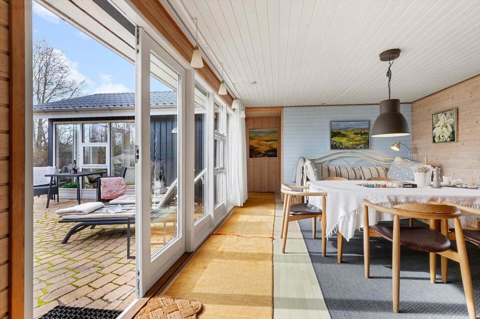 Ein Essbereich mit Tisch und Stühlen neben einer Terrasse mit Sitzgelegenheiten.