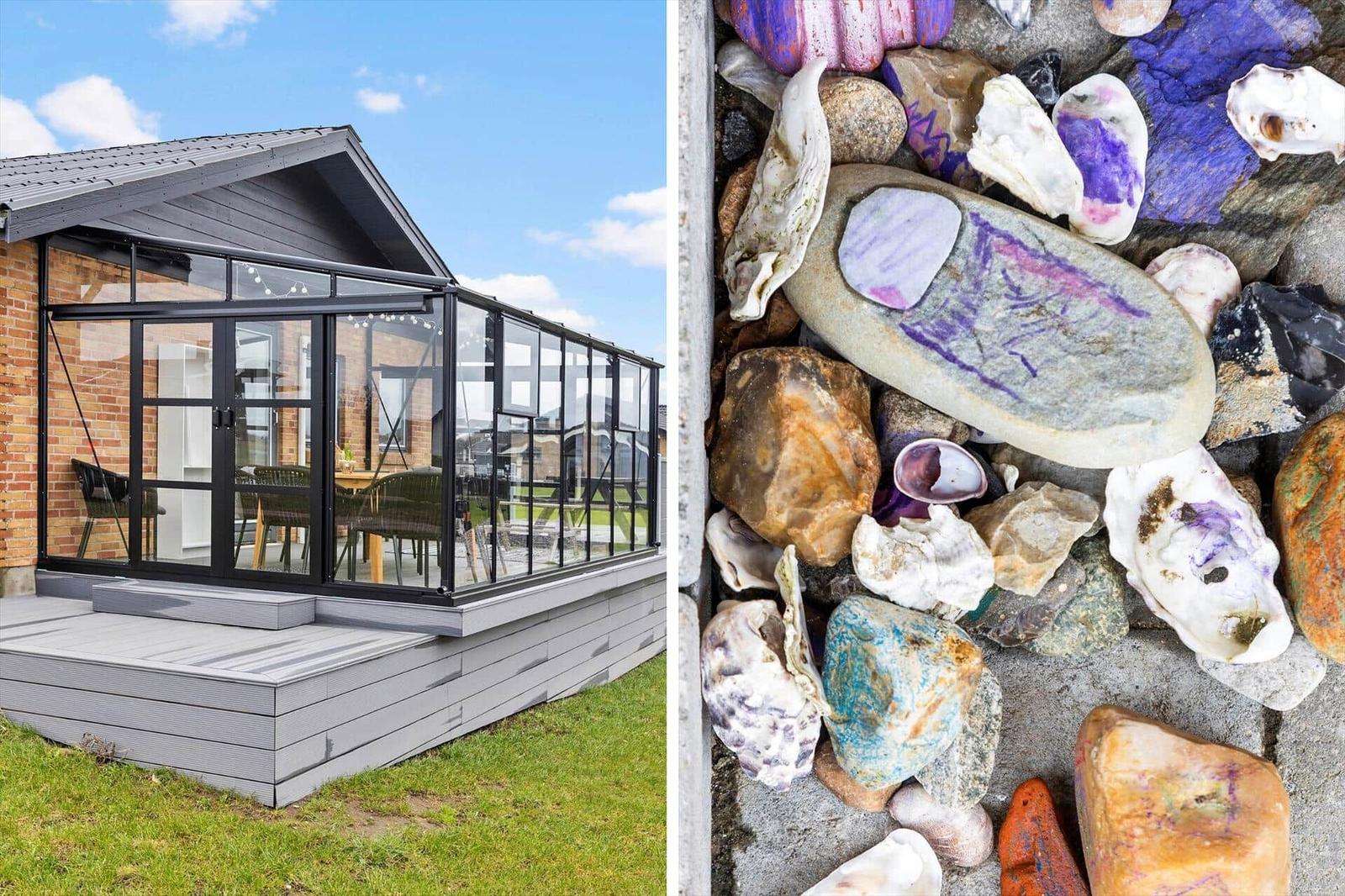 Terrasse mit Glasveranda und Steinwand mit Muscheln und Felsen.