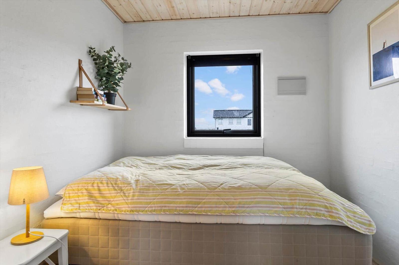 Schlafzimmer mit Bett, Fenster und Nachttisch