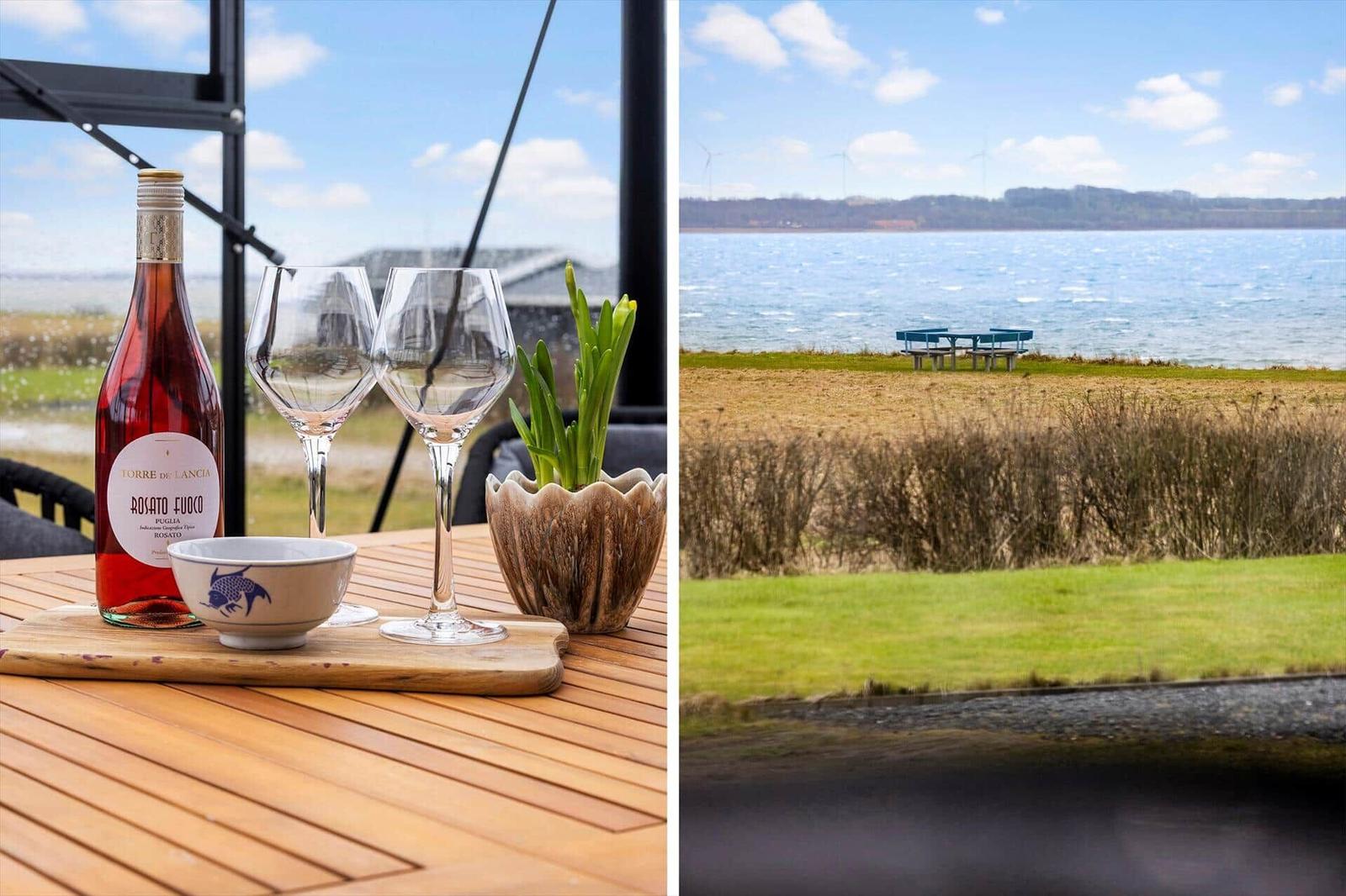 Tisch mit Wein und Gläsern vor Aussicht auf Wasser und Windräder