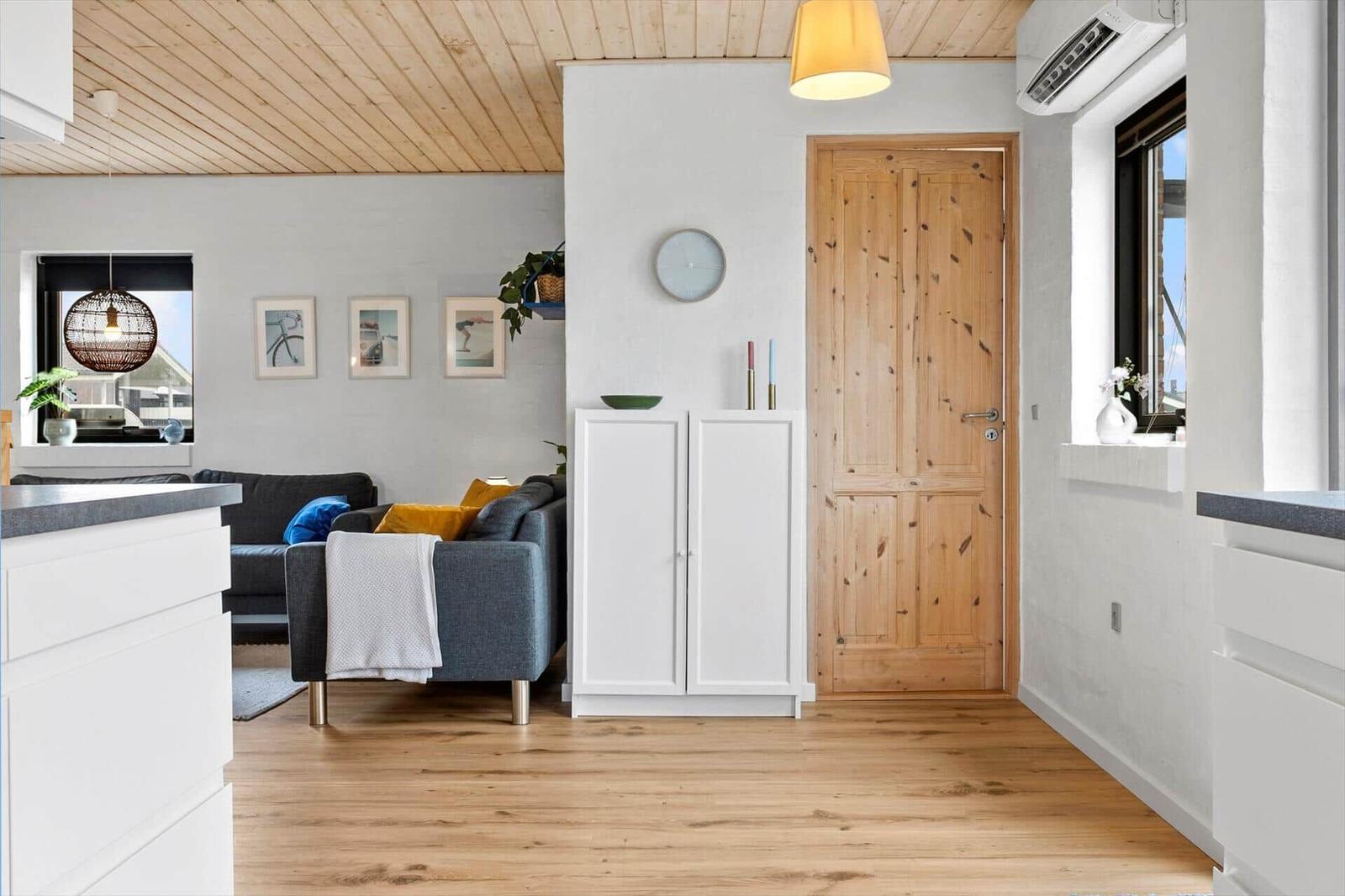 Wohnraum mit Holzboden, Sofa und Kücheninsel