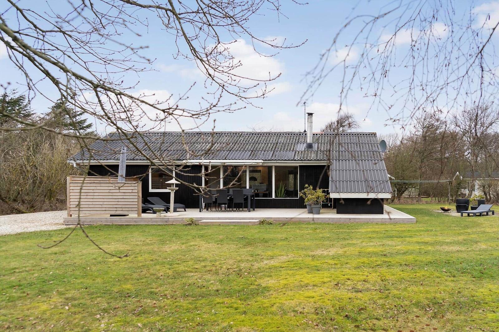Moderne Villa mit Terrasse, Garten und Außensitzgelegenheiten.