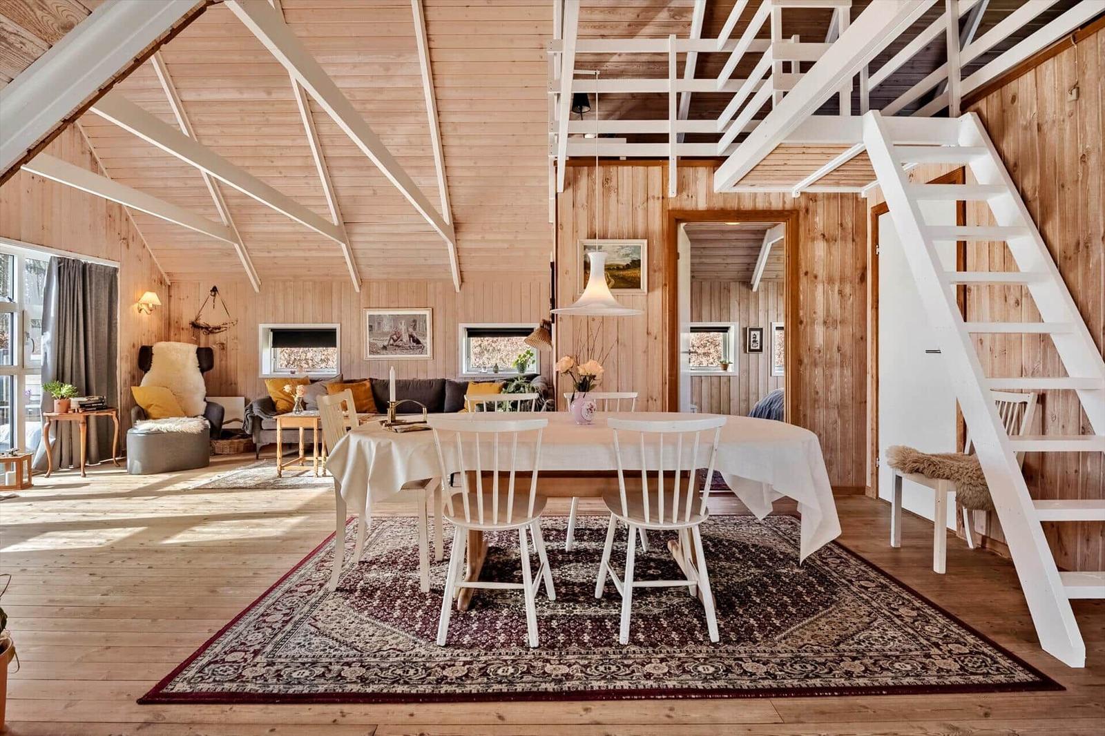 Haus mit Essbereich, Wohnbereich und Treppe zur oberen Etage.