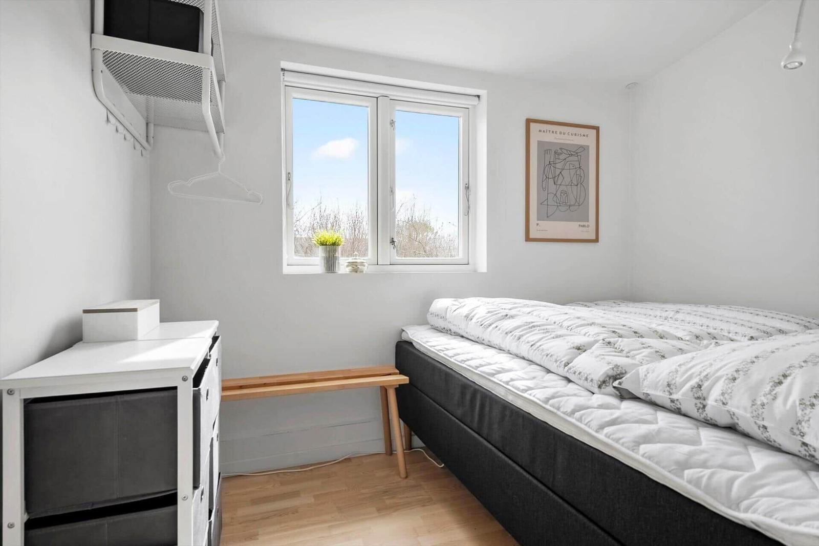 Schlafzimmer mit Bett, Fenster und Schrank.