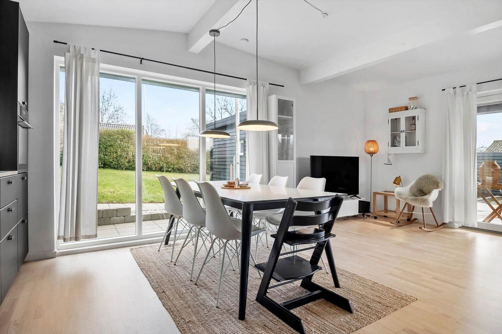 Moderne Esszimmer mit Tisch, Stühlen und Blick auf Garten.