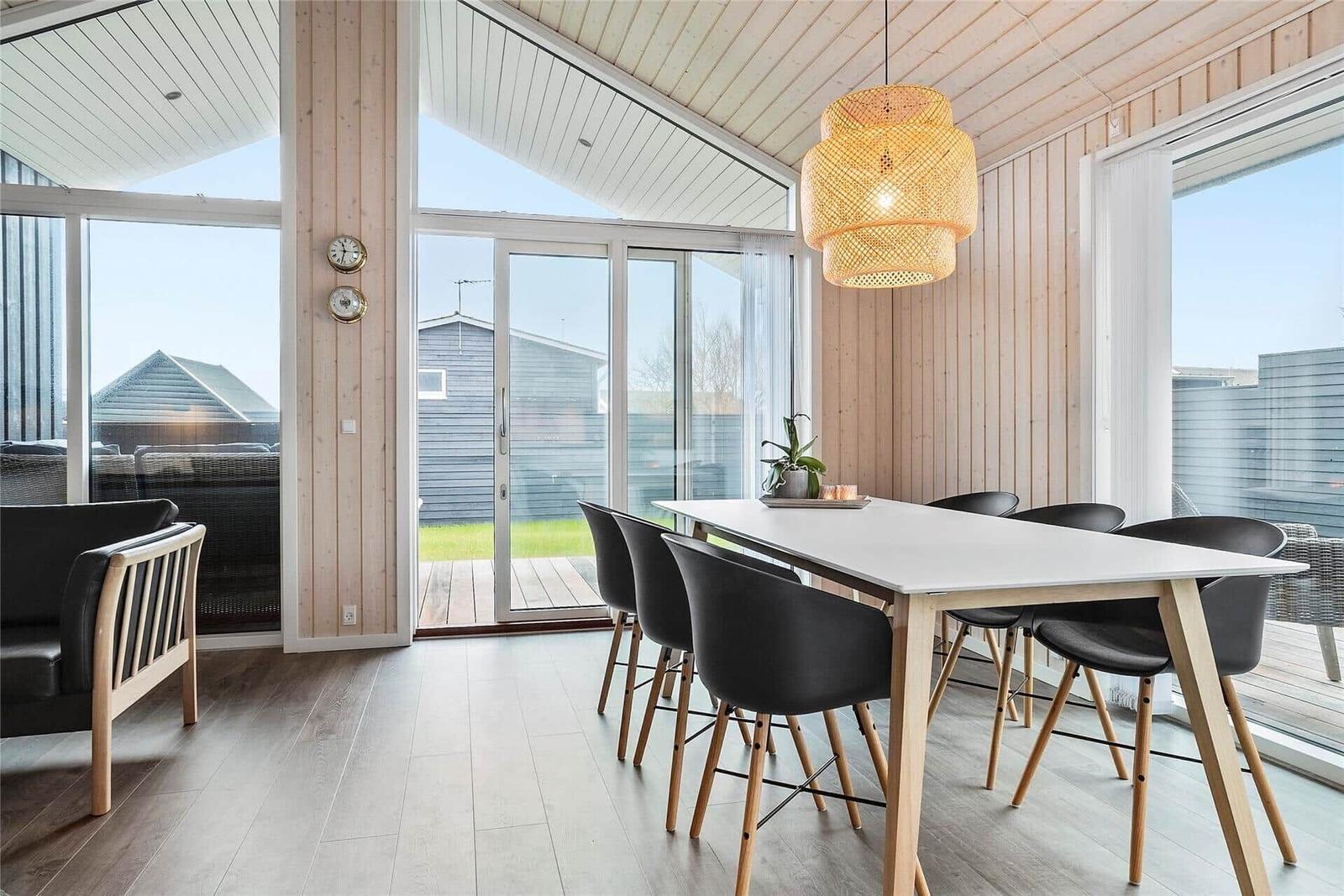 Essbereich mit Tisch, Stühlen und Glasfront zur Terrasse.