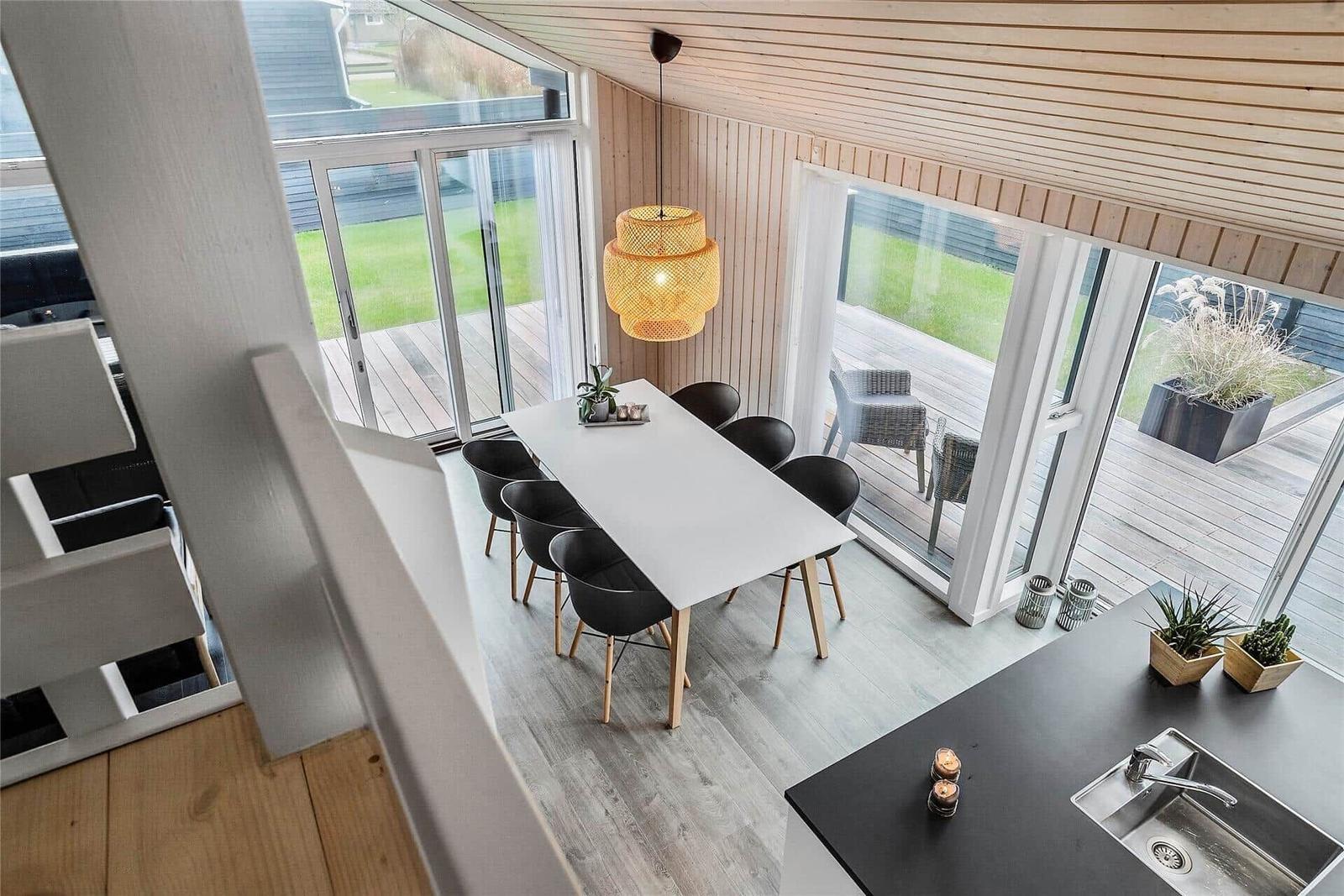 Essbereich mit Tisch und Stühlen, Küche und Terrasse mit Sitzgelegenheiten.