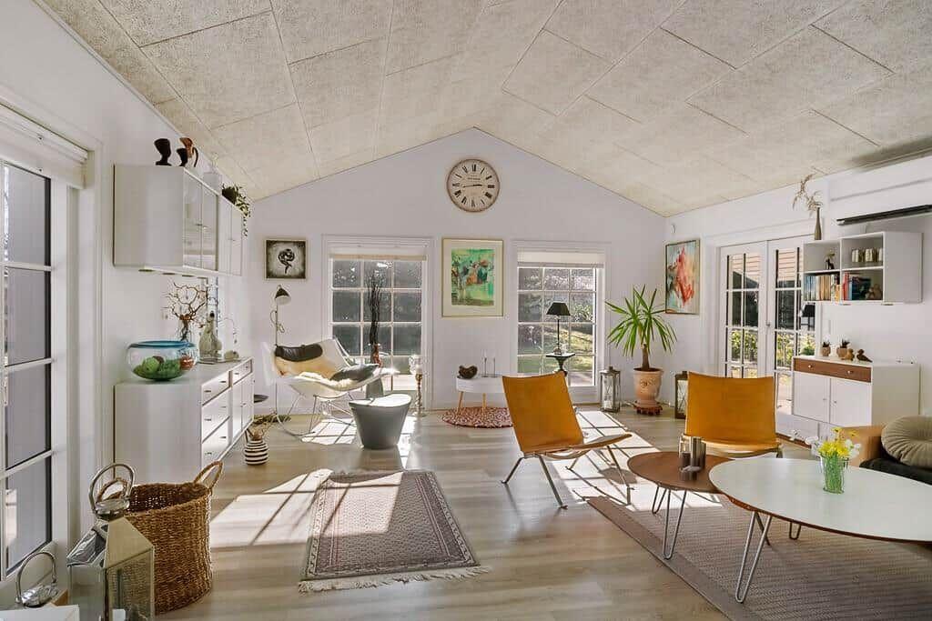 Living space with high ceiling, windows, and modern furniture.